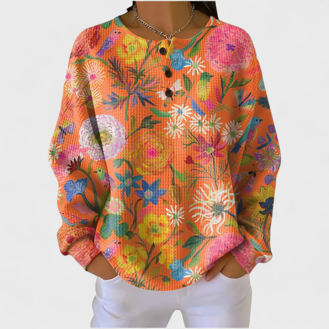 Faustine – Orange sweater with a colorful floral pattern